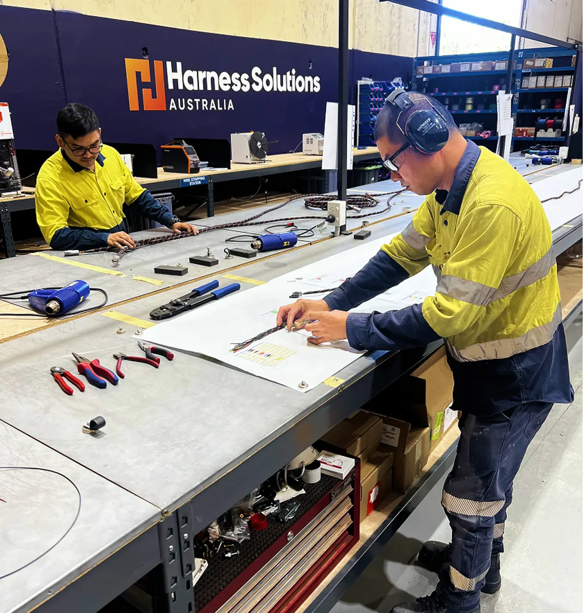 Harness Solutions Australia technicians building a harness on the workshop bench